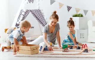 family-mother-and-children-play-a-toy-railway-in-playroom